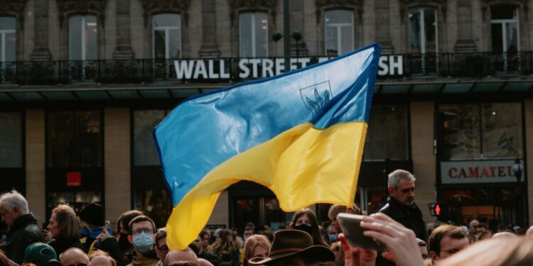 Blue and yellow Ukrainian Flag Waving Above Crowd of People